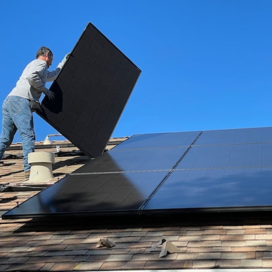 a worker installing solar panels on a cabin roof